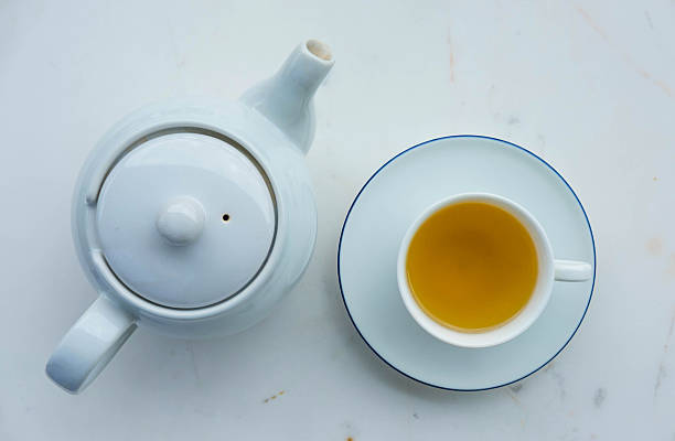 istock Tea pot and cup of tea on white marble desk 586179238