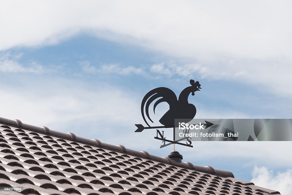 Weathervane Weathervane with cock above an arrow and the four cardinal points North East West South Abstract Stock Photo