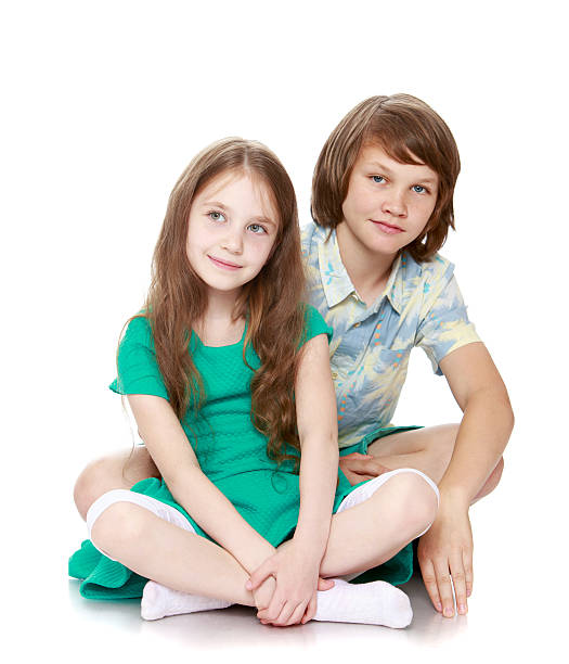 istock boy and his sister sitting on the floor 586181592