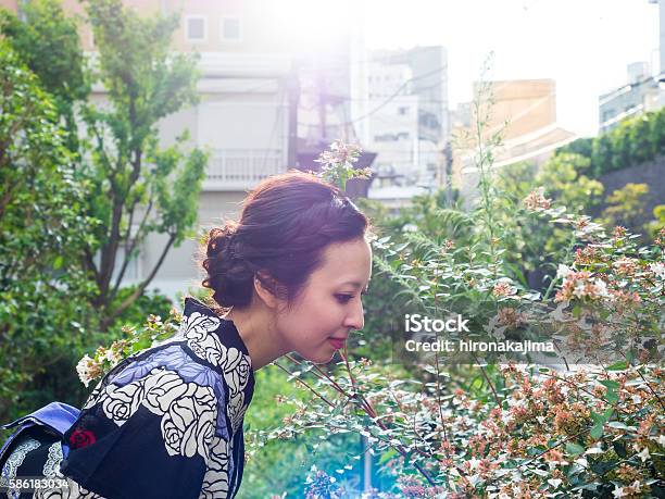 Japanese Young Yukata Woman Smelling Fragrance Of Flowers At Park Stock Photo - Download Image Now