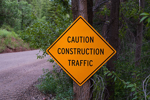 istock Caution Construction Traffic Sign and Dirt Road 586184828