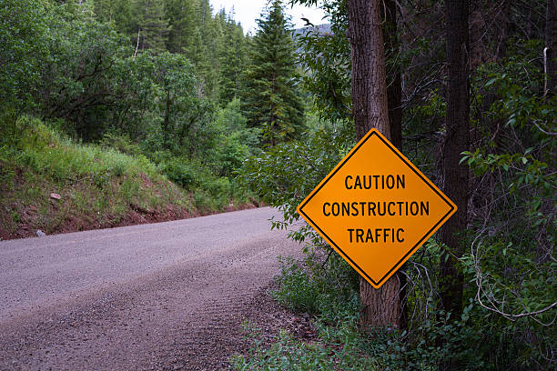 istock Caution Construction Traffic Sign and Dirt Road 586185272