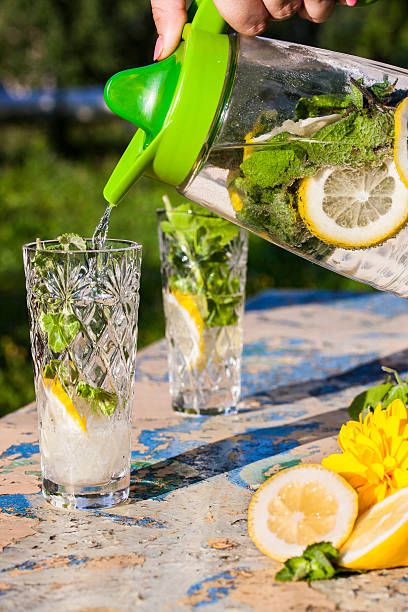 istock Lemonade pitcher with lemon and mint on garden table 586185516