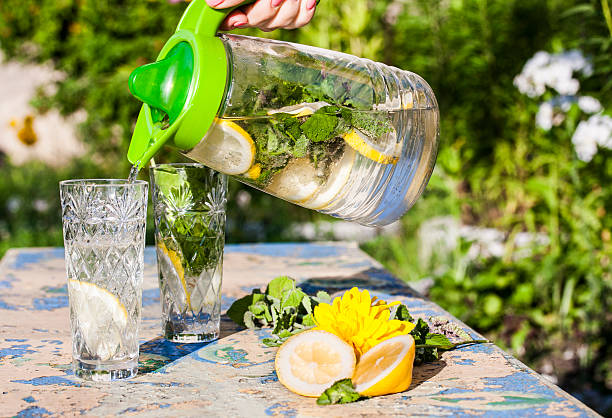 istock Lemonade pitcher with lemon and mint on garden table 586185644