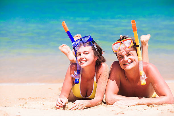 istock couple lying on summer beach sand with snorkel equipment 586188034