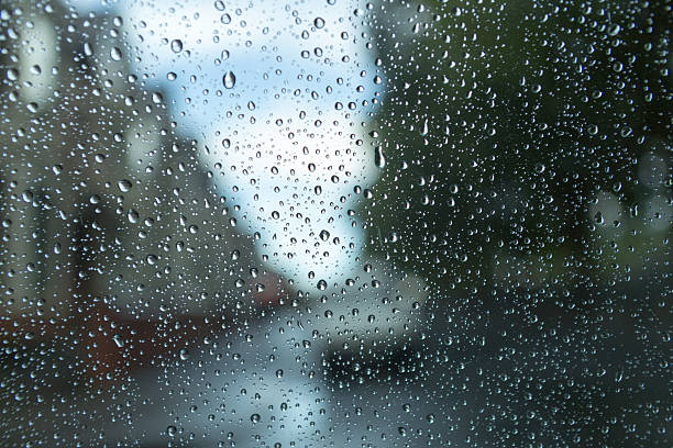 Blurred street scene through rain covered window stock photo