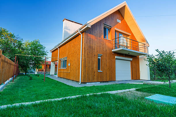 istock Wooden house with meadow in front of it 586190046