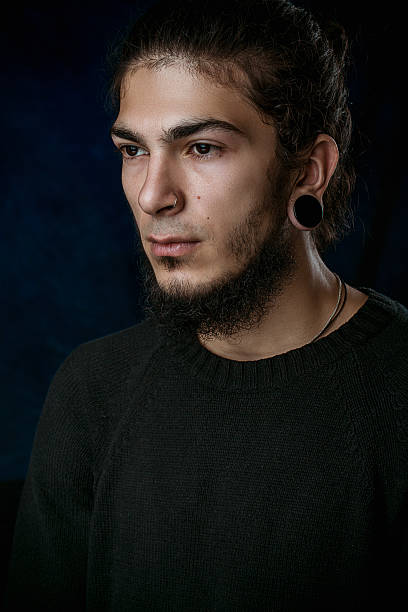 istock brutal young man with a beard against a dark background 586190670