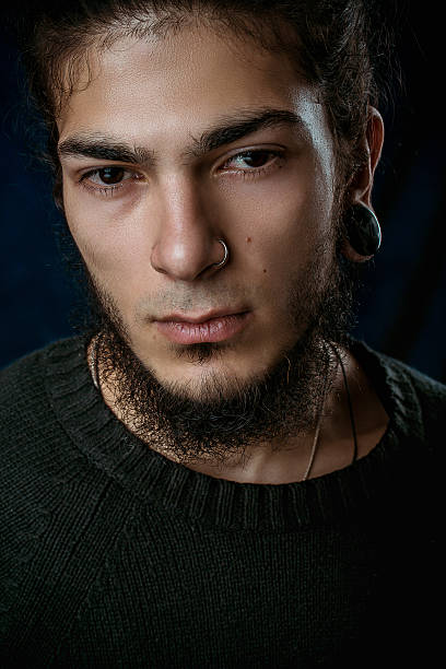 istock brutal young man with a beard against a dark background 586190804
