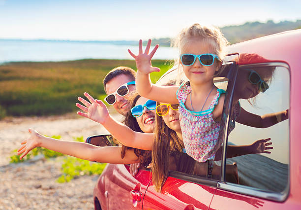 Portrait of smiling family with children at beach in car Portrait of a smiling family with two children at beach in the car.  Holiday and travel concept family vacation stock pictures, royalty-free photos & images
