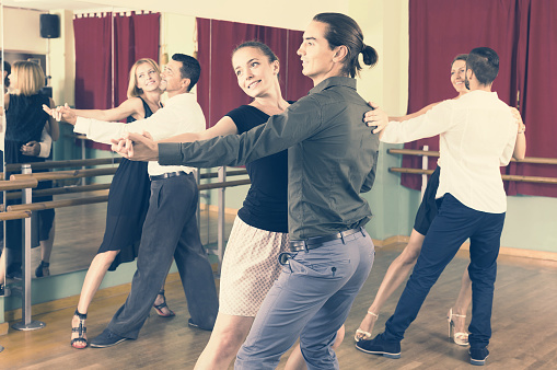 russian men and women enjoying of tango in class