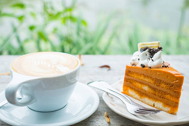 istock Hot Latte and Thai Tea Cake  on wooden desk 586197338