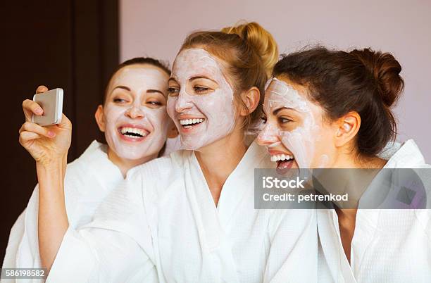 Drei Junge Glückliche Frauen Mit Gesichtsmasken Im Kurort Stockfoto und mehr Bilder von Kosmetikmaske