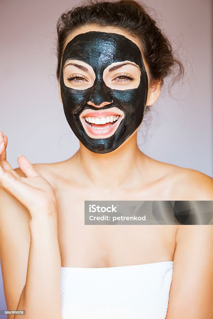 Jovem com máscara facial de lama negra terapêutica - Foto de stock de Cor Preta royalty-free