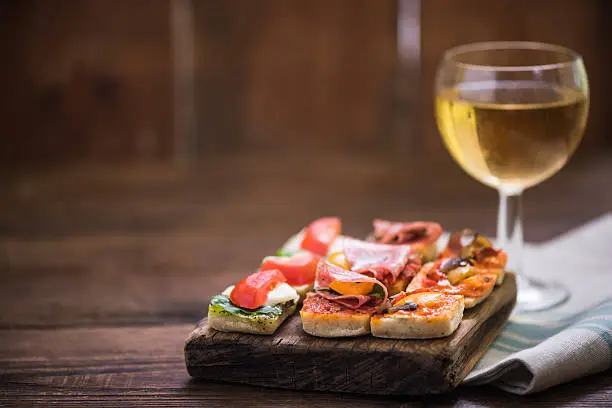 tapas and wine served on wooden rustic board