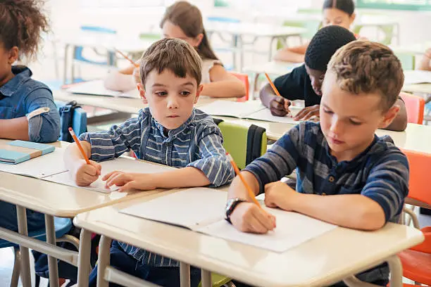 Photo of Elementary students taking a test in classroom.