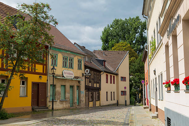 Berlin, Germany - August 1, 2016: The Kolk is the oldest settlement area in the district of Berlin Spandau. The row of houses on the left shows some very old houses. A house which is the former Kolkschänke. On its façade hangs a logo \
