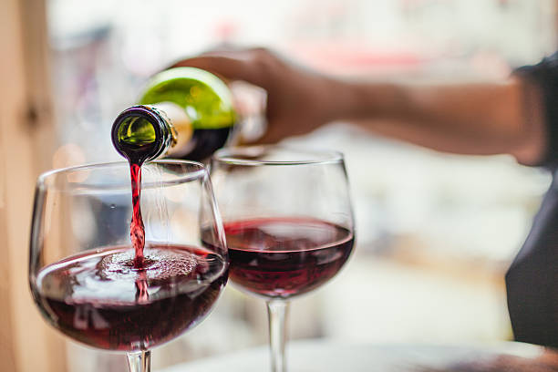 istock Pouring red wine in glasses 586204206