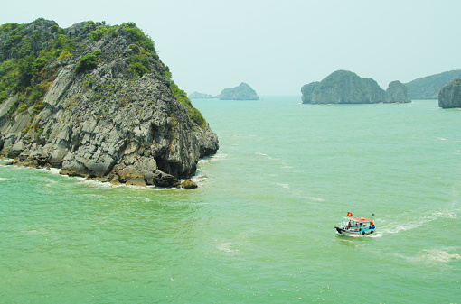 motorboat surrounding the limestones in halong bay