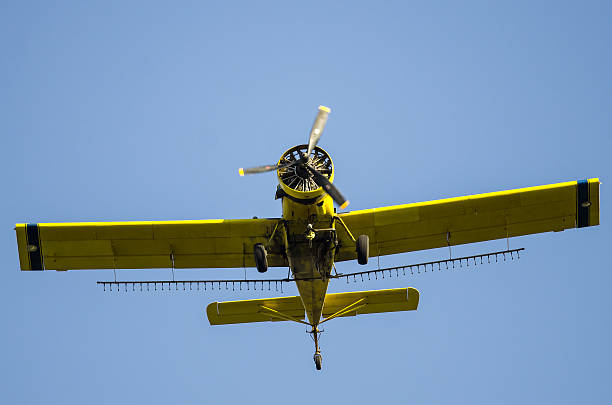 istock Yellow Crop Dusting Plane Flying in a Blue Sky 586209490