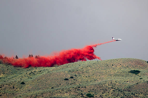 istock White Aircraft Dropping Fire Retardant While Battling the Raging Wildfire 586209836