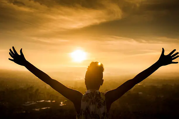 Photo of African American Woman Raising Arms at Sunset