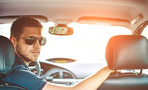 istock Handsome man driver looking back and parking car 586211272