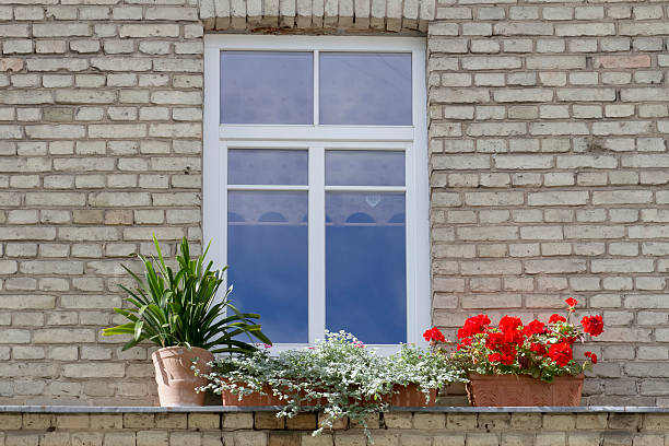 istock Small modern plastic window with flowers on vintage old brick 586348536