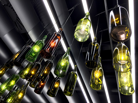 Magnificent retro light lamp decor made of wine bottles. Toned