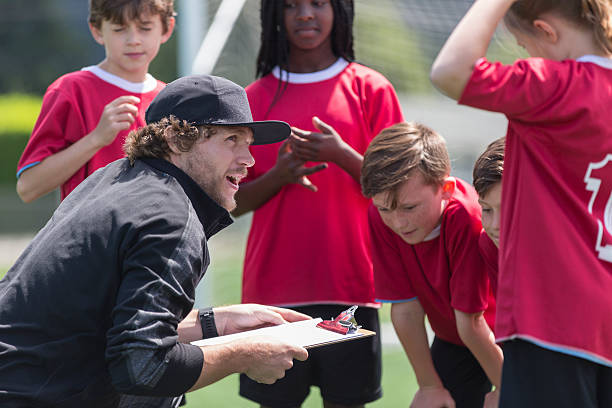 A coach with a group of young soccer players.