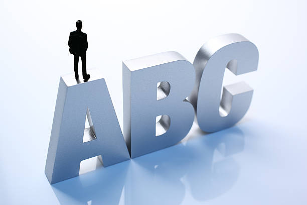 istock Figurine Businessman Standing on Big Letters ABC 586355810