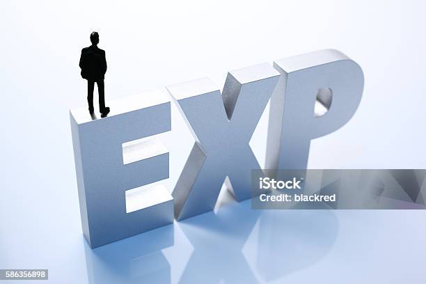 Figurine Businessman Standing On Big Letters Exp Stock Photo - Download Image Now - Adult, Adults Only, Alphabet