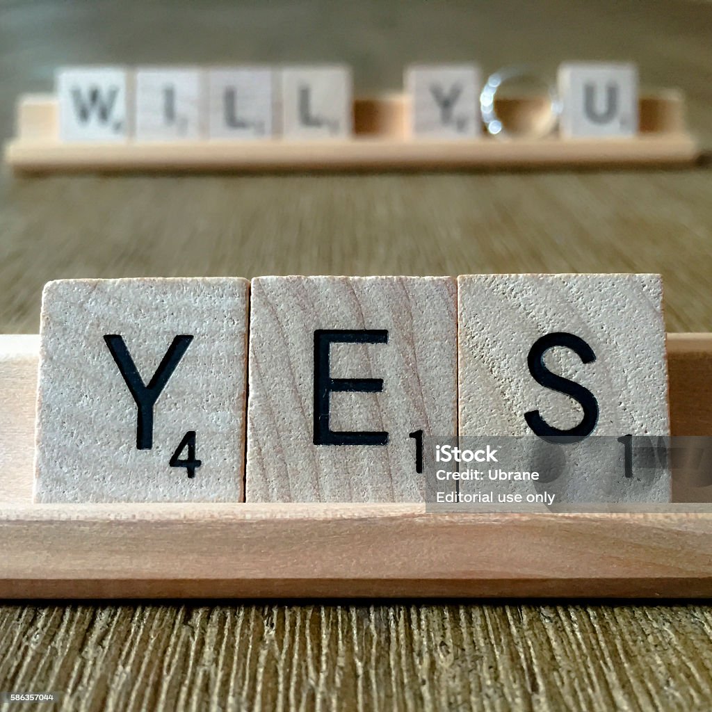 Will You Marry Me? Toronto, ON, Canada – July 16, 2015: wooden Scrabble tiles spelling out the word YES to the question WILL YOU with engagement ring on the background. Shot on a wooden table in natural light. Scrabble Stock Photo Will You Marry Me? Toronto, ON, Canada – July 16, 2015: wooden Scrabble tiles spelling out the word YES to the question WILL YOU with engagement ring on the background. Shot on a wooden table in natural light. Scrabble Stock Photo
