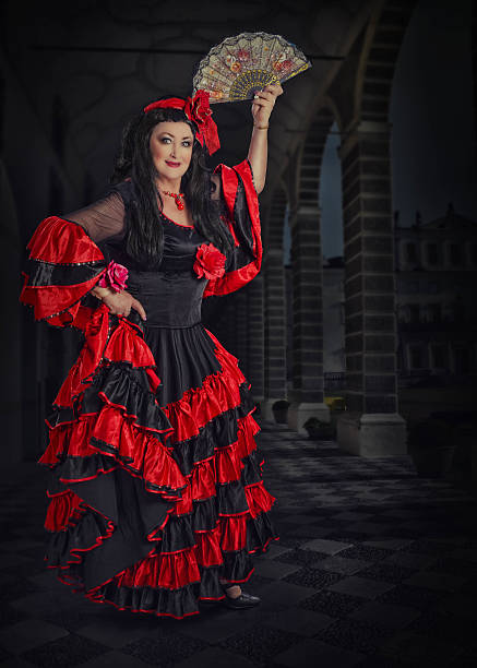 istock Flamenco female dancer posing with fan on stage 586357356