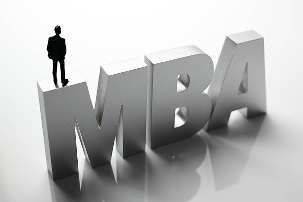 istock Figurine Businessman Standing on Big Letters MBA 586357414