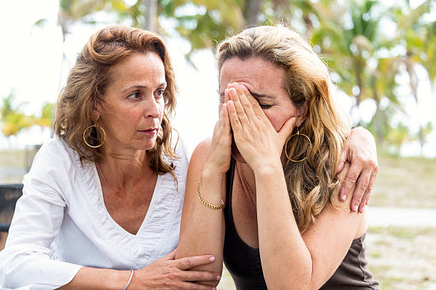 Comforting friend Desperate lesbian woman being comforted by her wife sad gay stock pictures, royalty-free photos & images