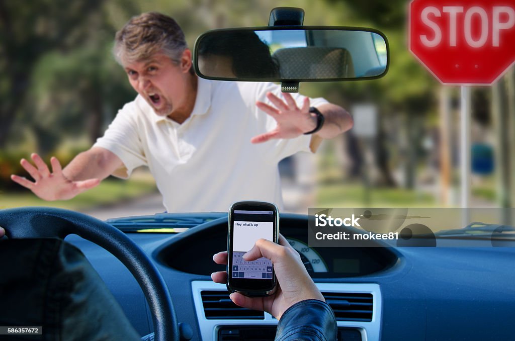 Texting and driving wreck hitting pedestrian An irresponsible texting driver is about to run over a pedestrian at an intersection which shows how dangerous texting and driving is. Stop the text and stop the wrecks. Driving Stock Photo