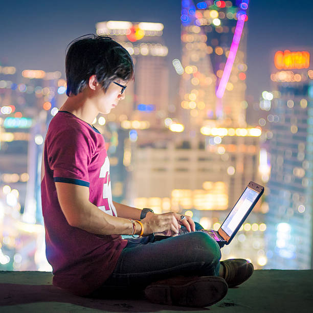 istock Asian Businessman using a laptop and smart phone analysis stock 586358976