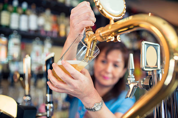 bartender gießt eine prise bier - orientale stock-fotos und bilder