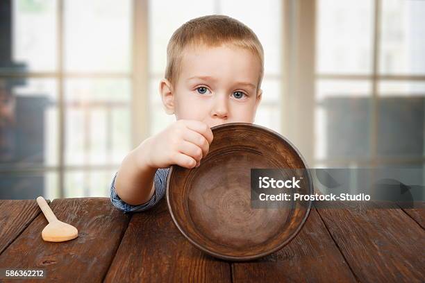 Cute Blonde Boy Shows Empty Plate Hunger Concept Stock Photo - Download Image Now - Child, Hungry, Famine