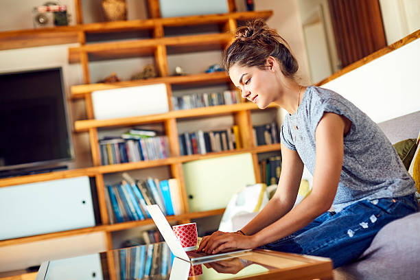 istock Beautiful young woman using laptop at coffee table 586363906