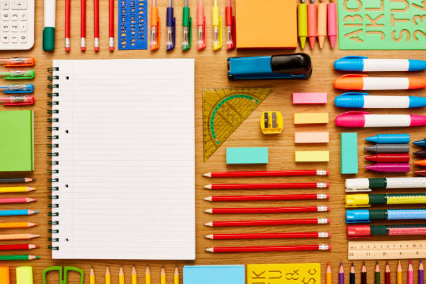 istock Blank spiral notebook surrounded by school supplies on wooden ta 586364340