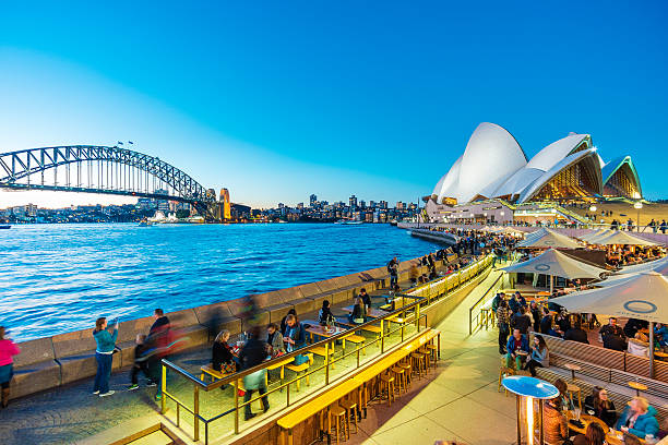 люди обедают в ресторанах на открытом воздухе в круговой набережной в сиднее - sydney australia sydney harbor bridge opera house sydney opera house стоковые фото и изображения