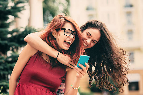 istock Two friends texting outdoor 586366460