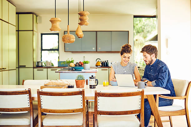 istock Young male and female hipsters using laptop at dining table 586366698