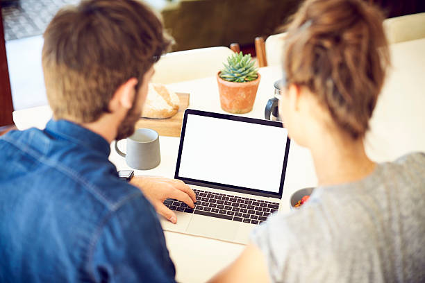 istock Rear view of bloggers using blank screen laptop at table 586367504