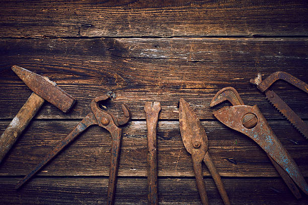 istock Old rusted tools on a wooden boards 586369116