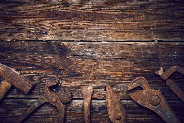 istock Old rusted tools on a wooden boards 586369252