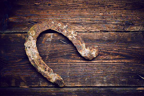 istock Old rusty horseshoe on vintage wooden board 586370484
