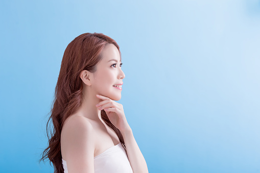 Beauty woman with charming smile to you with isolated blue background, asian